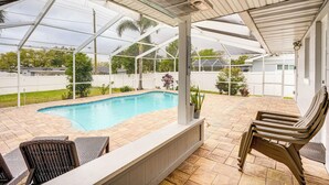 Ein  überdachter Poolbereich im Freien mit Terrasse, Liegestühlen und Blick auf die umliegende Landschaft.
