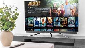 A flat-screen TV mounted on a wall displaying a movie selection menu. - Luxury 2 Bed Apartment (Birmingham)