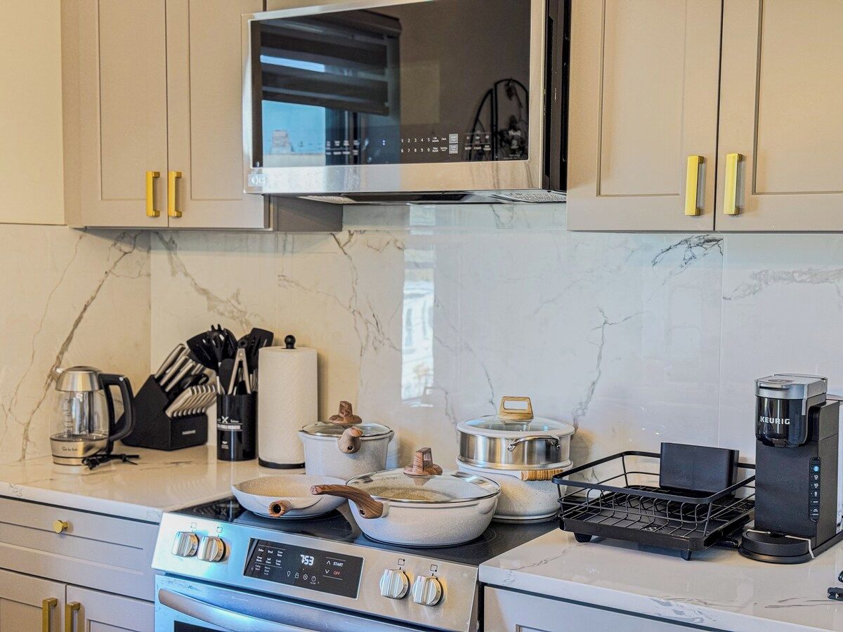 A kitchen with a stove, microwave, and coffee maker.
