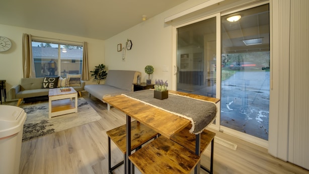 Een moderne woonkamer met een bank, salontafel en eettafel.