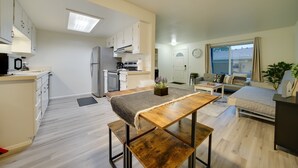 Een moderne keuken met witte kasten, een houten eettafel en een inbouwoven.