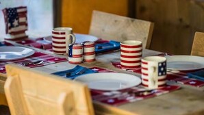 A dining table set with plates, cutlery, and American flag-themed mugs. - Accessible, Glamping Tent in Bar Harbor,Just 4 miles from Acadia National Park (Bar Harbor)