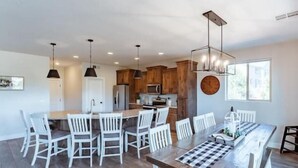 A modern kitchen with wooden cabinets, a central island, and pendant lighting. - Zion views- R Family Square + Resort Access (Orderville)