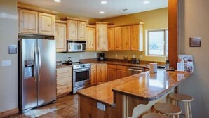 Una cocina moderna con armarios de madera, electrodomésticos de acero inoxidable y encimera de granito.