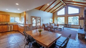 Una cocina amplia con un gran comedor, armarios de madera y una chimenea de piedra.