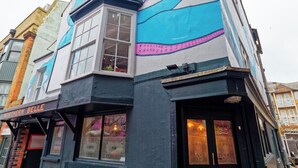 A building with a distinctive blue and white facade, featuring a large window and a closed door. - The Northern Belle (Margate)