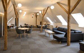A modern interior with high ceilings, exposed wooden beams, and a mix of seating arrangements including tables and sofas. - Beautiful home in Brørup with WiFi (Brørup)