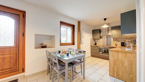 Une cuisine équipée d’une table à manger, de chaises, d’un four encastré et d’un four à micro-ondes.