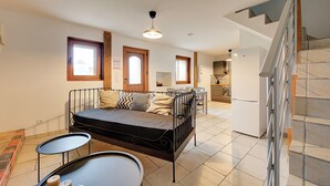 Un appartement moderne avec un lit, une table à manger et une cuisine en arrière-plan.