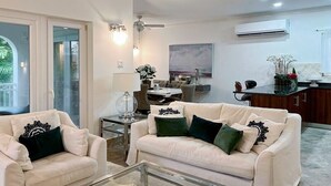 Una sala de estar con sofá, una mesa de centro y un comedor con mesa y sillas.