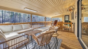 A wooden deck with a sofa, chairs, and a table. - Cozy & fun getaway on the water near Myrtle Beach! (Conway)