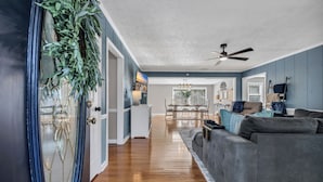 A living room with a grey sofa, wooden flooring, and a ceiling fan. - Cozy & fun getaway on the water near Myrtle Beach! (Conway)
