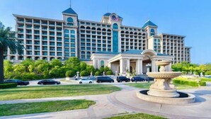 A large hotel with a central entrance, multiple floors, and a fountain in the courtyard. - Evergrande Hotel，Tianjin Dongli Lake (Tianjin)