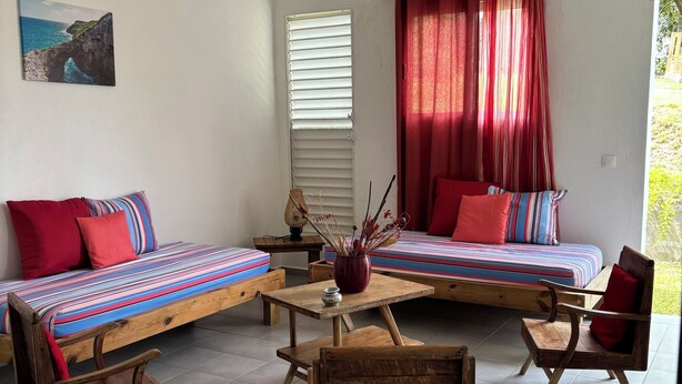 A cozy room with a bed, a chair, a small table, and a ceiling fan. - Kaz Ti Plézi (Capesterre-de-Marie-Galante)