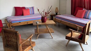 A cozy room with a bed, a chair, a small table, and a ceiling fan. - Kaz Ti Plézi (Capesterre-de-Marie-Galante)