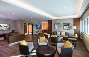 Un hall d’entrée spacieux avec un comptoir d’accueil, des coins salon confortables et des œuvres d’art accrochées aux murs.