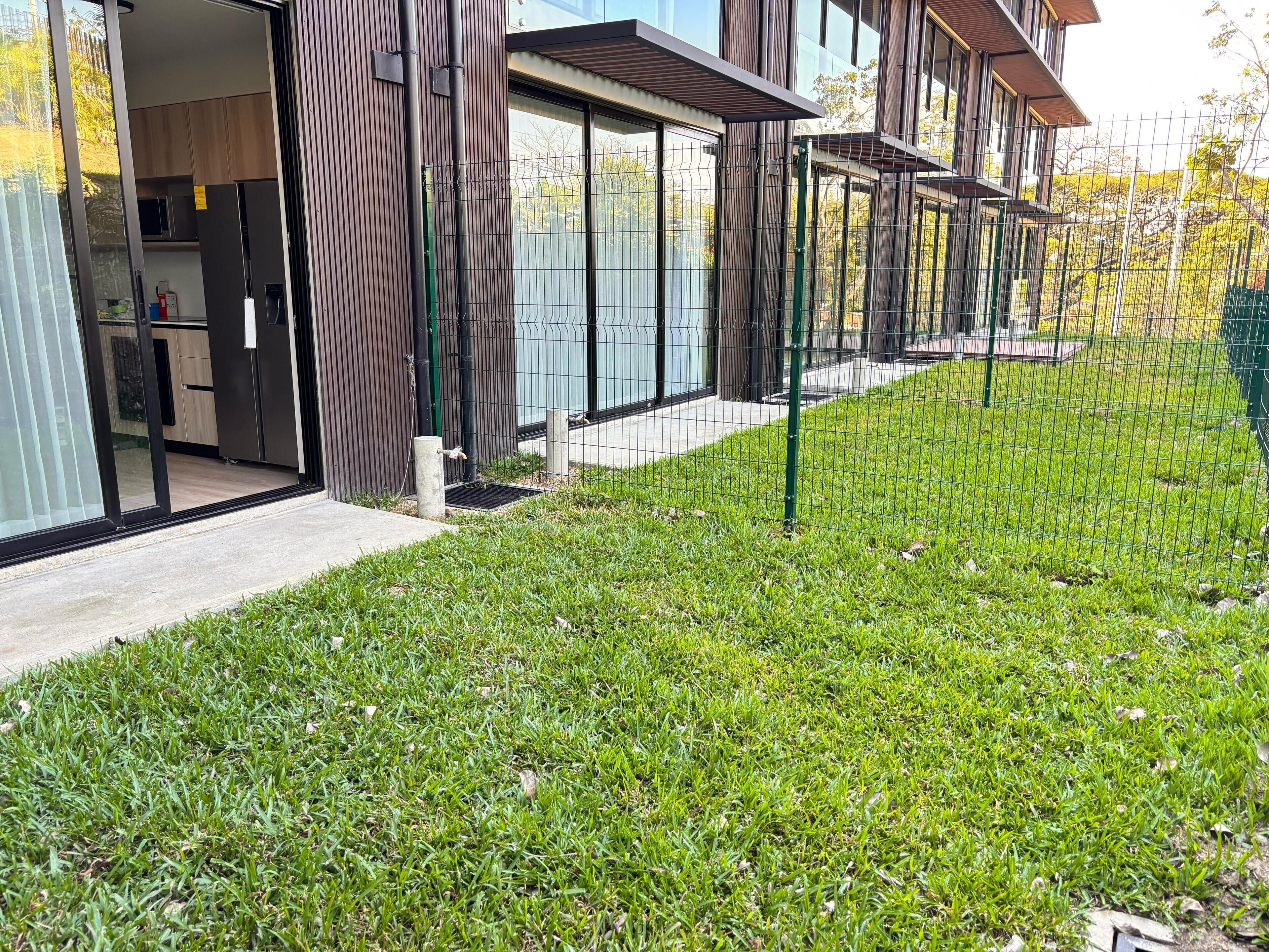 A modern building with large windows and a well-maintained lawn.