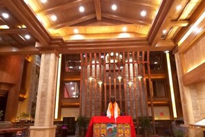 A room with a wooden ceiling, a red altar, and a large window. - Da Zang Sunlight Hotel (Zoige)
