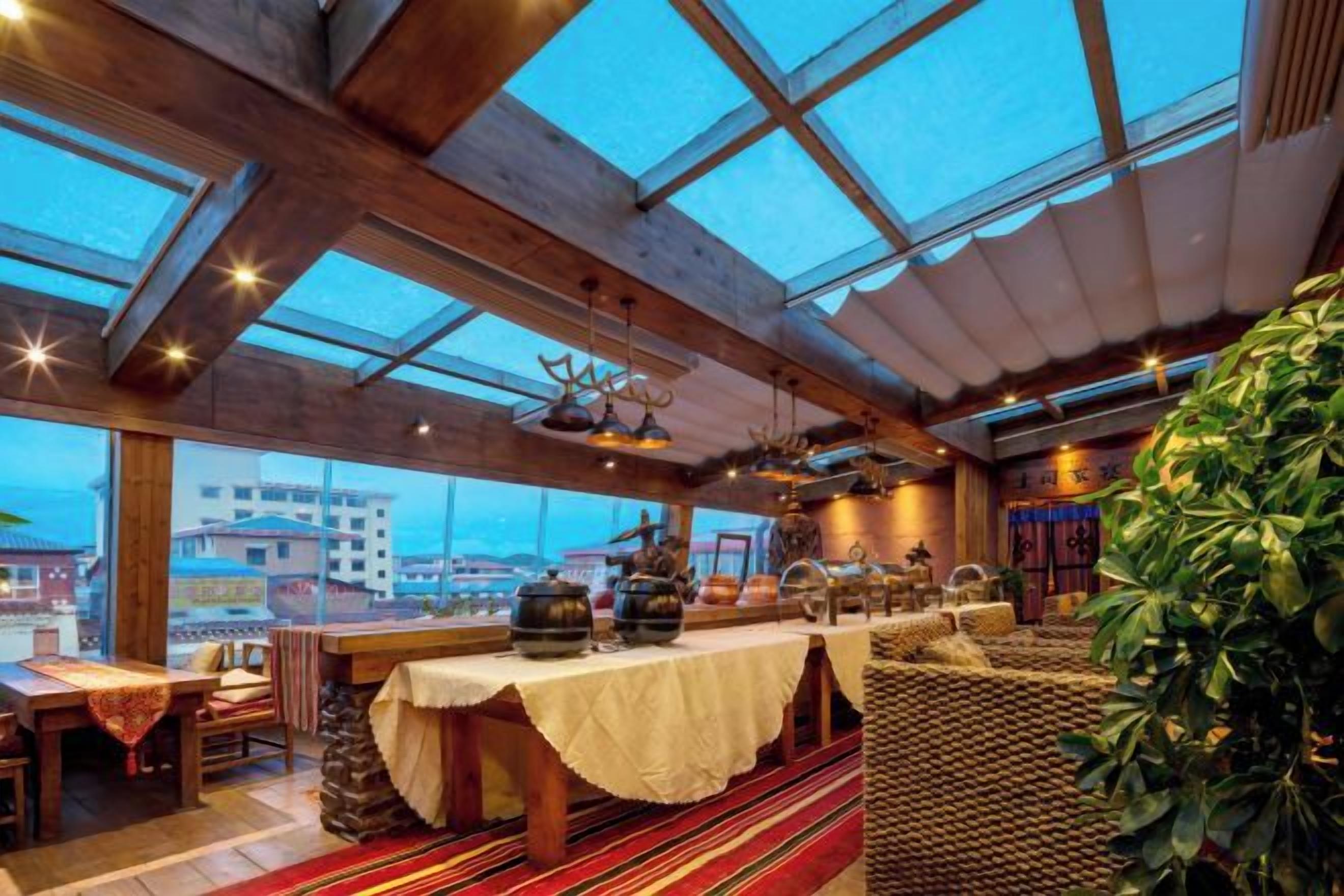 Ein Restaurant mit hoher Decke, Holzbalken und Blick auf die Stadt.