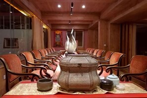 A long dining table with chairs, a central decorative object, and a patterned table runner. - Da Zang Sunlight Hotel (Zoige)