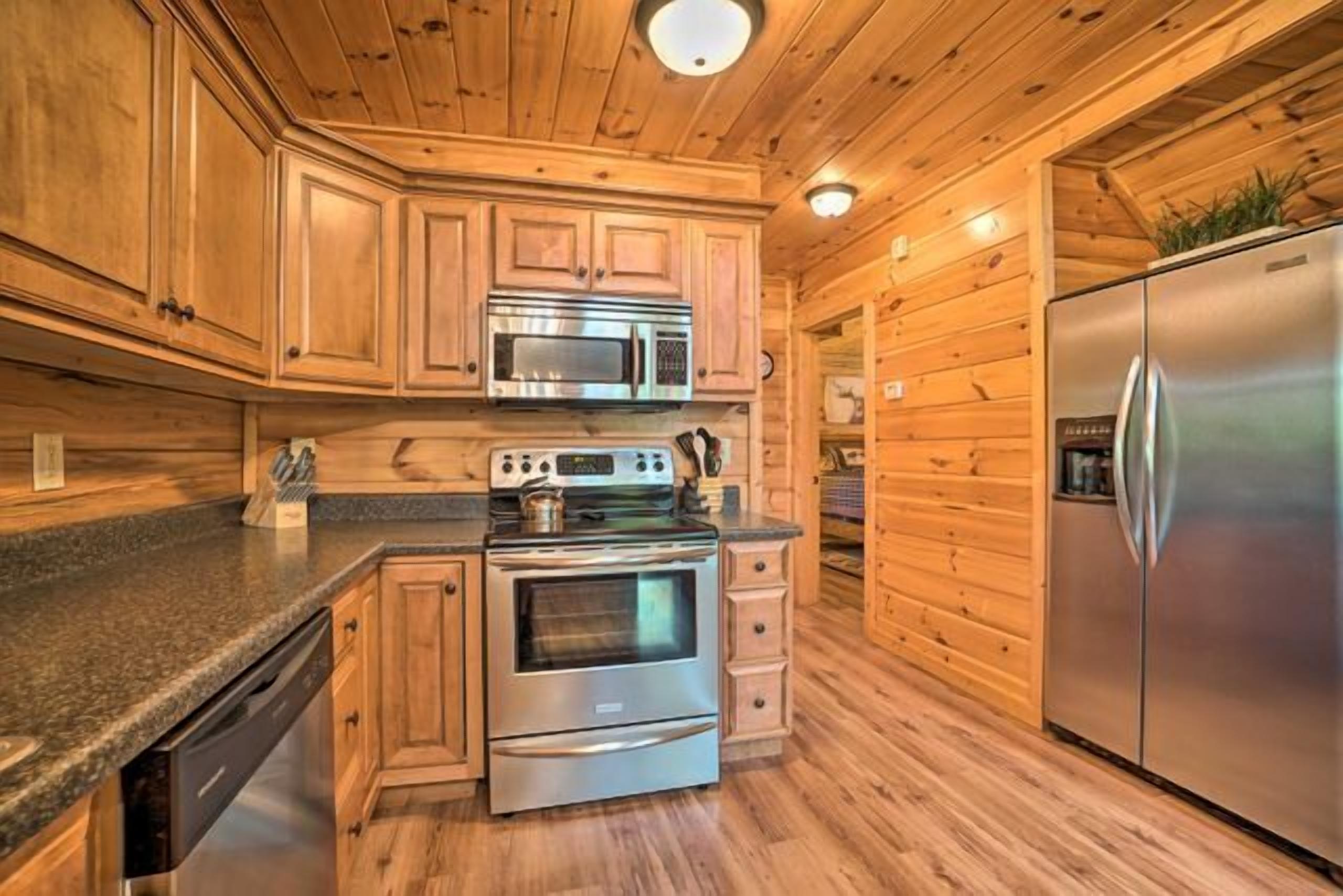 Une cuisine de style rustique, avec des éléments en bois et des appareils électroménagers intégrés, notamment un four à micro-ondes, un four et un réfrigérateur.