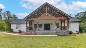 A two-story house with a stone foundation, a gabled roof, and a front porch with a railing. - 8 Mi to Jordan Lake: Spacious New Hill Home (New Hill)