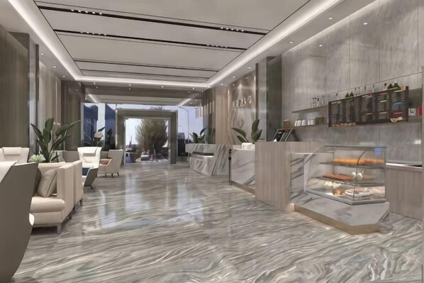 A modern hotel lobby with marble flooring, a reception desk, seating area, and a glass display case with pastries. - Fuyoupeng Hotel (Shenzhen)