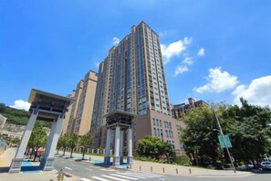 A high-rise building with a modern architectural style, featuring a prominent entrance with a covered walkway. - Meidi Hotel (Shenzhen Bao'an Airport Pingluanshan Metro Station Branch) (Shenzhen)