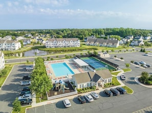 Ett bostadsområde med en swimmingpool, en tennisbana och en parkeringsplats.