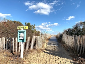 Walk along the sandy pathway to the entrance of Rodney, marked by a signpost with a display case.