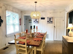 Enjoy meals in this dining area with a table for four, surrounded by matching chairs and nautical-themed artwork.