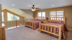 A bedroom with two wooden beds, a ceiling fan, and large windows. - Cabin 109 - Open Loft/ Modern/Clean/Comfortable (Walker)