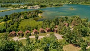 A lodge with multiple cabins surrounded by dense forest and a lake. - Cabin 109 - Open Loft/ Modern/Clean/Comfortable (Walker)
