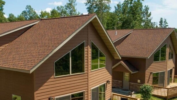 A two-story house with a deck, large windows, and a covered patio area. - Cabin 109 - Open Loft/ Modern/Clean/Comfortable (Walker)