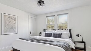 A bedroom with a bed, a map on the wall, and a window. - Linden Hills Edina. Remolded Home Near the Lakes. King Bed. Sleeps 10. (Minneapolis)