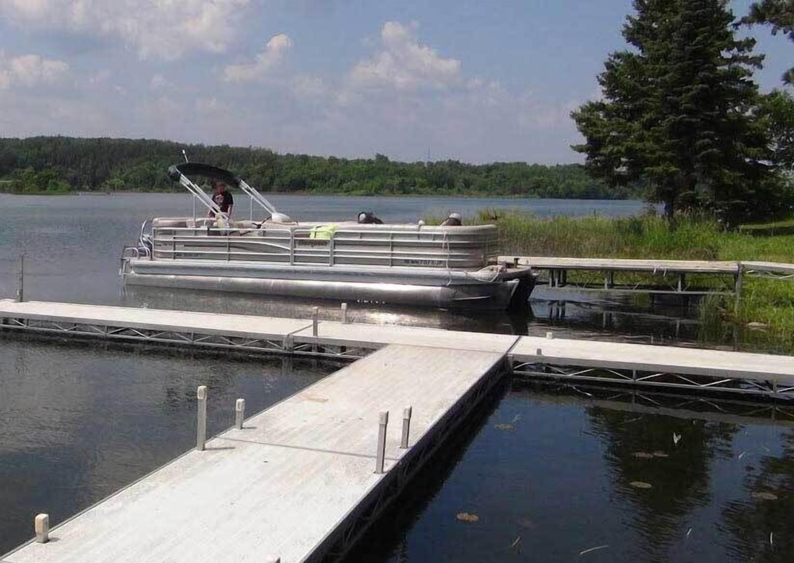 Un bateau était amarré à un quai, avec un lac paisible et une forêt en arrière-plan.