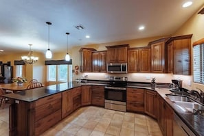 Enjoy cooking in this well-equipped kitchen with a central island, microwave, oven, and sink.