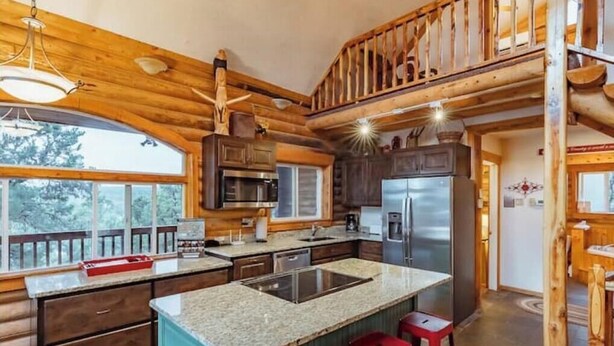A spacious kitchen with granite countertops, stainless steel appliances, and a large island with stools. - Zion Views- The Ranch House +Resort Access (Orderville)