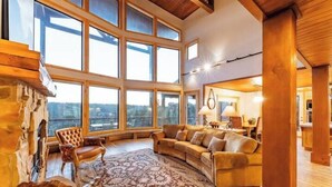 A spacious living room with a large window, a fireplace, and a cozy seating area.