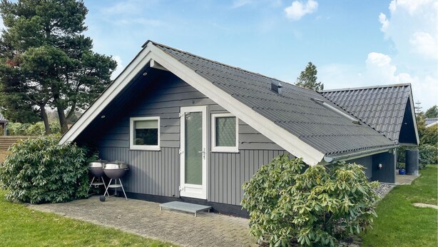 A modern house with a sloped roof, a front door, and a small porch area. - 3 bedroom nice home in Væggerløse (Væggerløse)