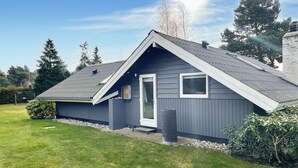 A modern house with a sloped roof, a small porch, and a well-maintained lawn. - 3 bedroom nice home in Væggerløse (Væggerløse)