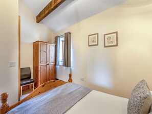 A bedroom with a wooden bed, a wardrobe, a chair, and two framed pictures on the wall. - Engine House - UK48912 (Allonby)