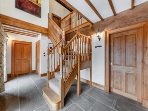 Una scala in legno con corrimano, che conduce a un piano superiore.