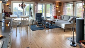 A modern living room with a sofa, chairs, a dining table, and a kitchen area with a stove. - 2 bedroom amazing home in Agdenes (Agdenes)