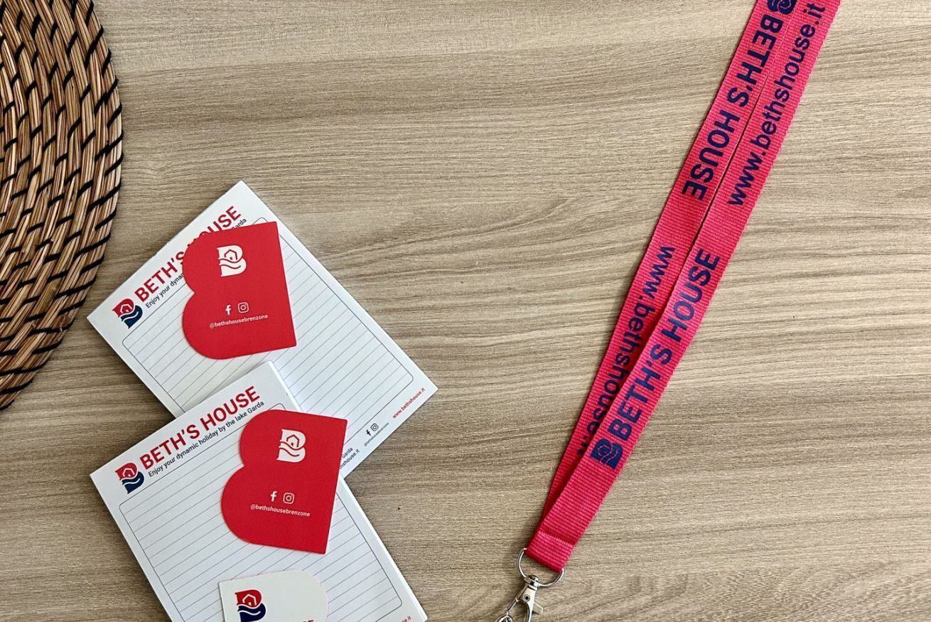Two business cards and a lanyard with the text "BETH'S HOUSE" and a website URL.