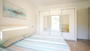 A bedroom with a bed, a large window, and a sliding door leading to another room. - 2 bedroom nice home in Imperia (Imperia)