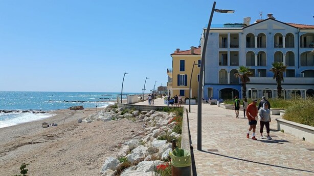 A coastal promenade with buildings, a beach, and a clear sky. - P049 – Porto Recanati, comfortable studio apartment with sea view (Porto Recanati)