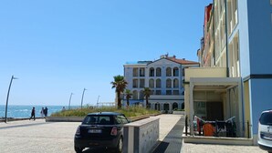 A building with a large entrance, a paved area in front, and a view of the sea. - P049 – Porto Recanati, comfortable studio apartment with sea view (Porto Recanati)