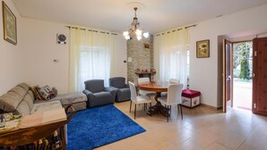A living room with a sofa, armchairs, a dining table with chairs, a chandelier, and a blue rug. - Stunning home in Poggio d'Acona (Poggio d'Acona)