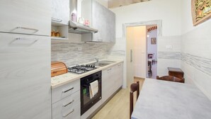 A compact kitchen with a gas stove, oven, and modern cabinetry. - Stunning home in Poggio d'Acona (Poggio d'Acona)